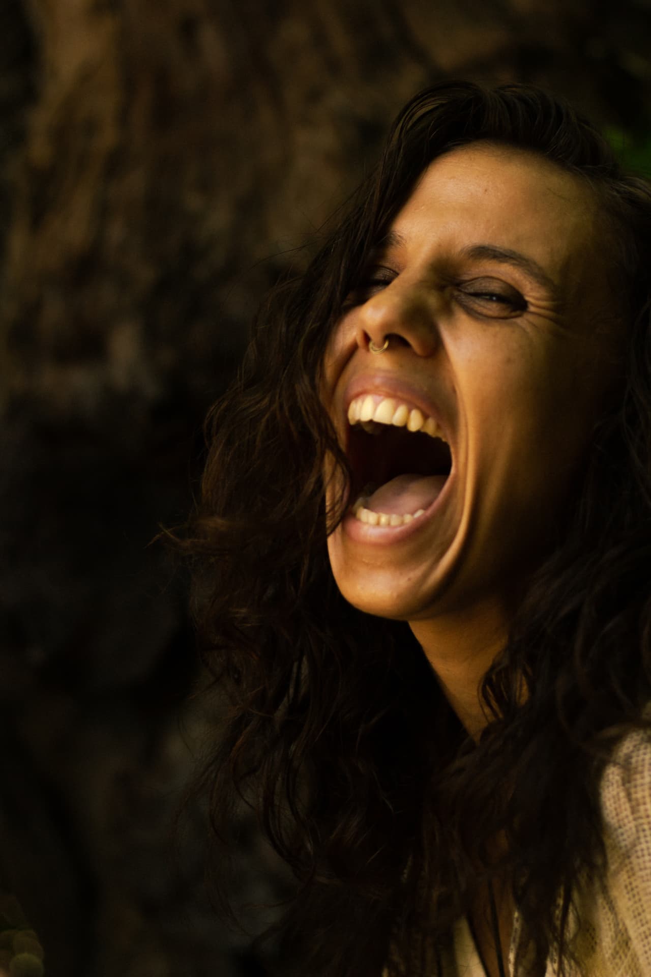 Woman releasing a raw, embodied scream in golden light