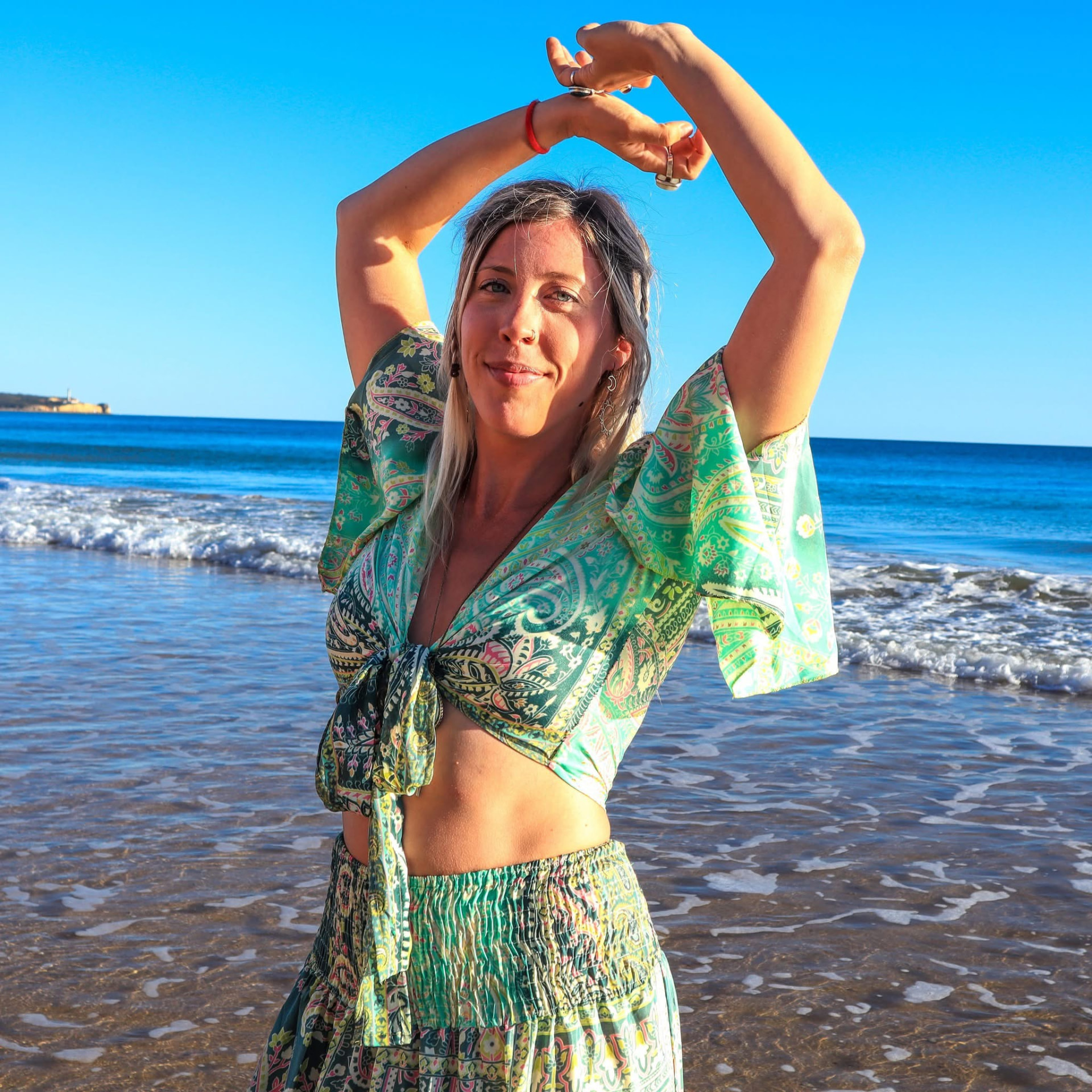 Portrait of Amy Ellis on the shoreline, arms raised
